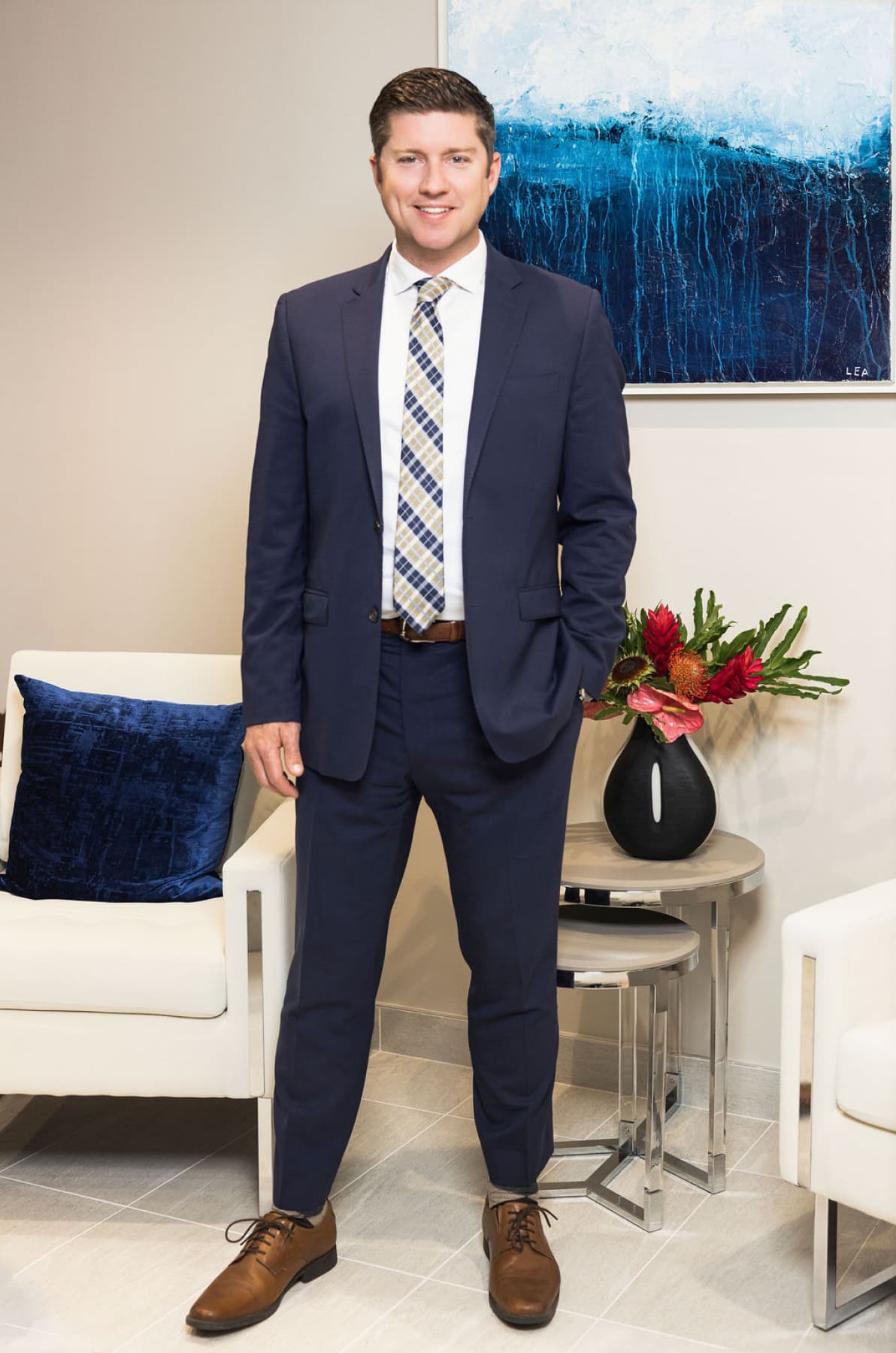 Andrew S. Kerns standing in a modern office, professionally dressed