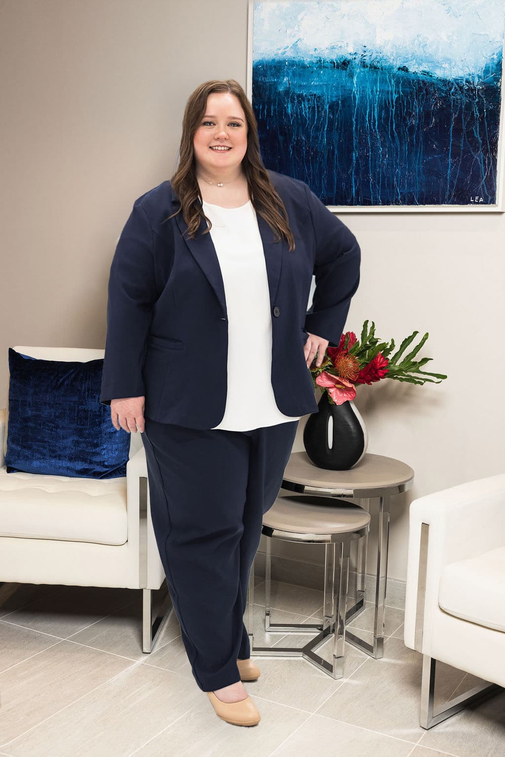 Megan N. Erinakes standing in a modern office, professionally dressed