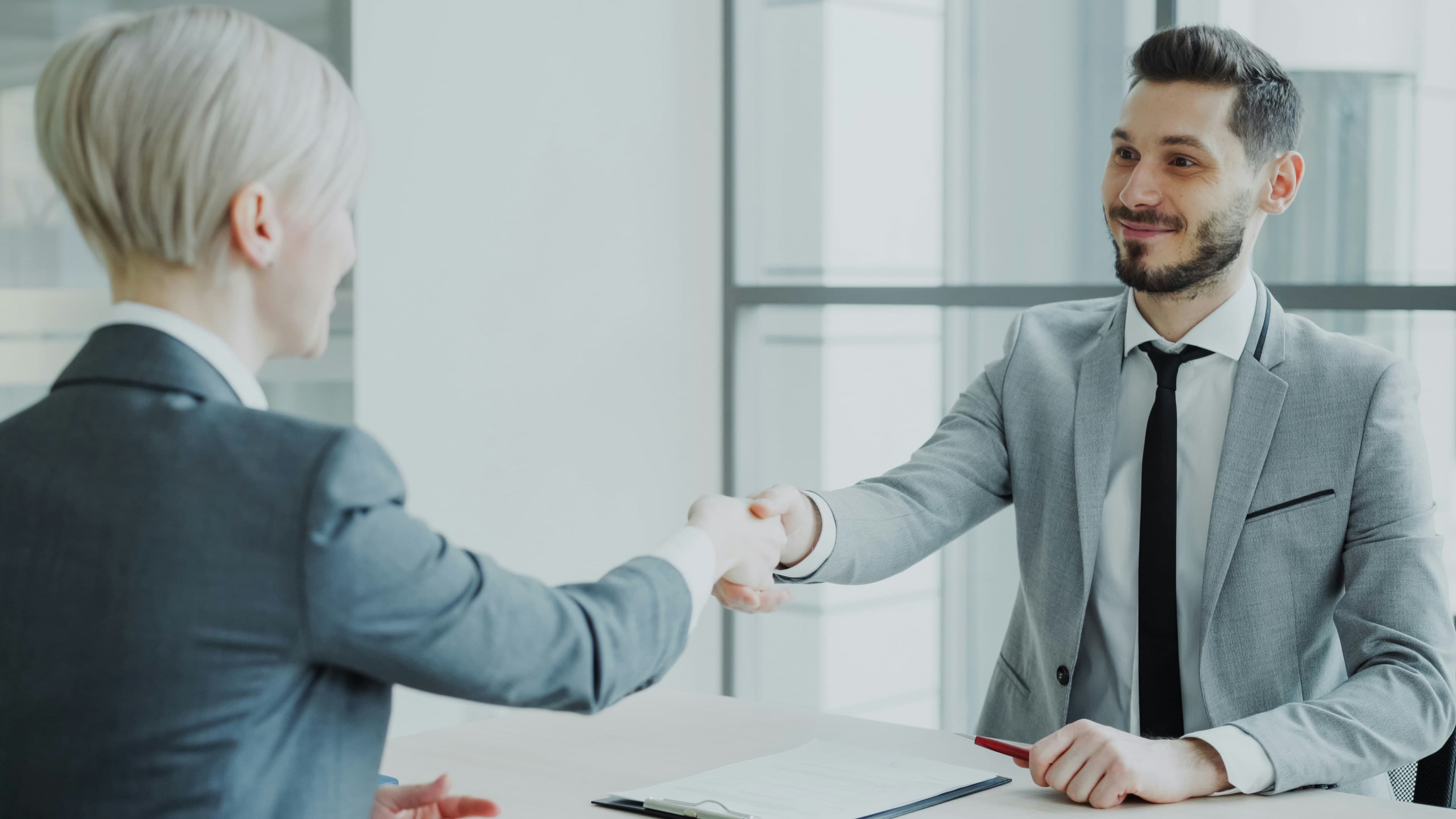 Two business partners shaking hands in a professional setting