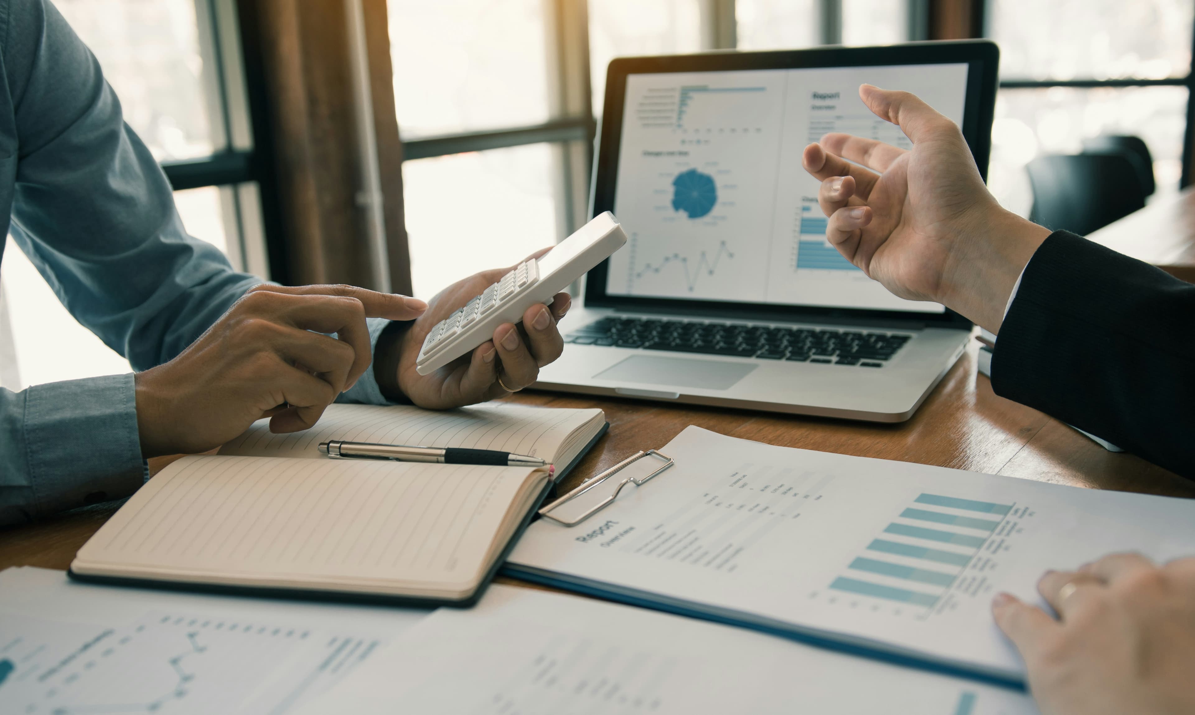 Couple reviewing financial documents with an attorney at a desk