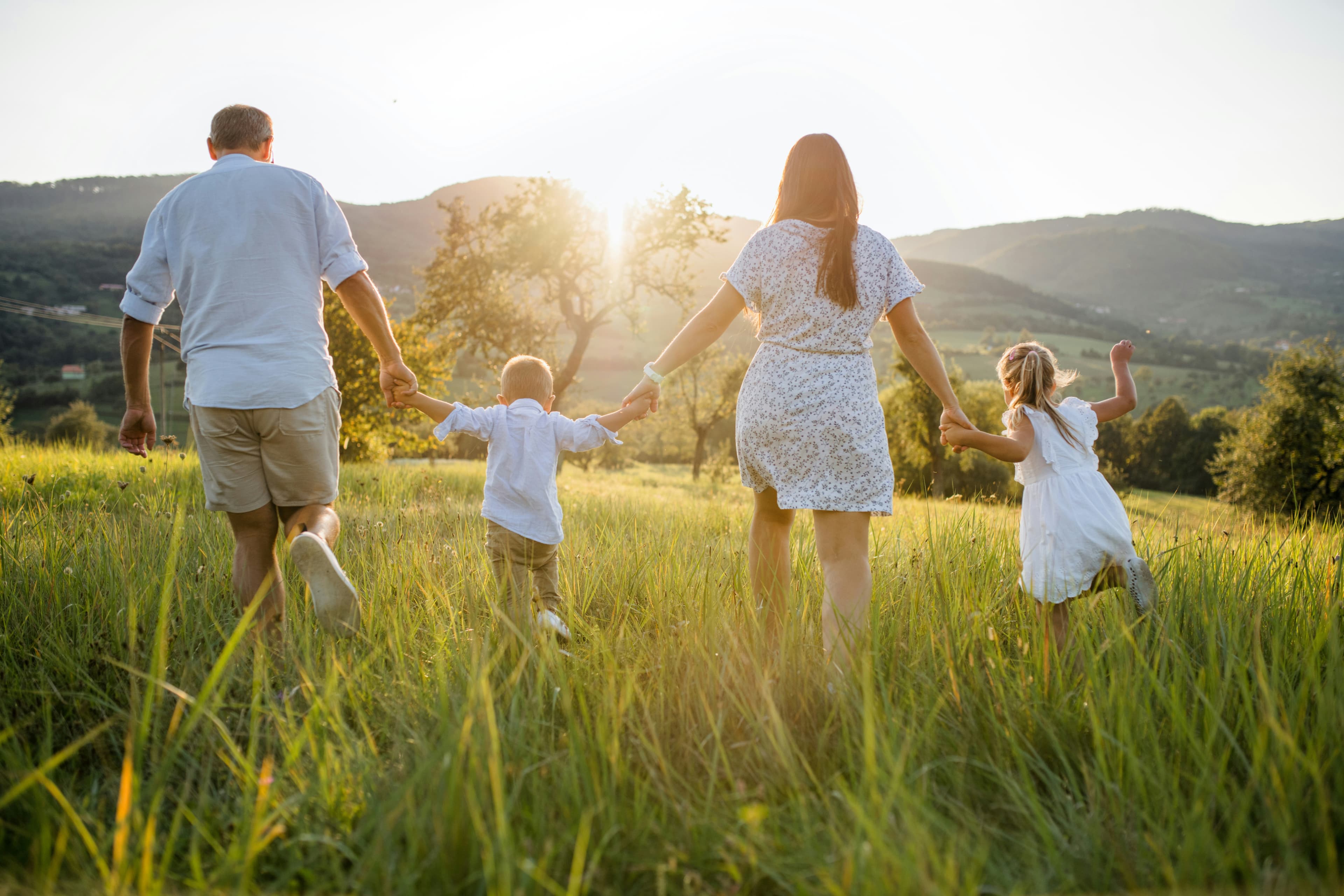 Parent walking with their child in a sunlit field