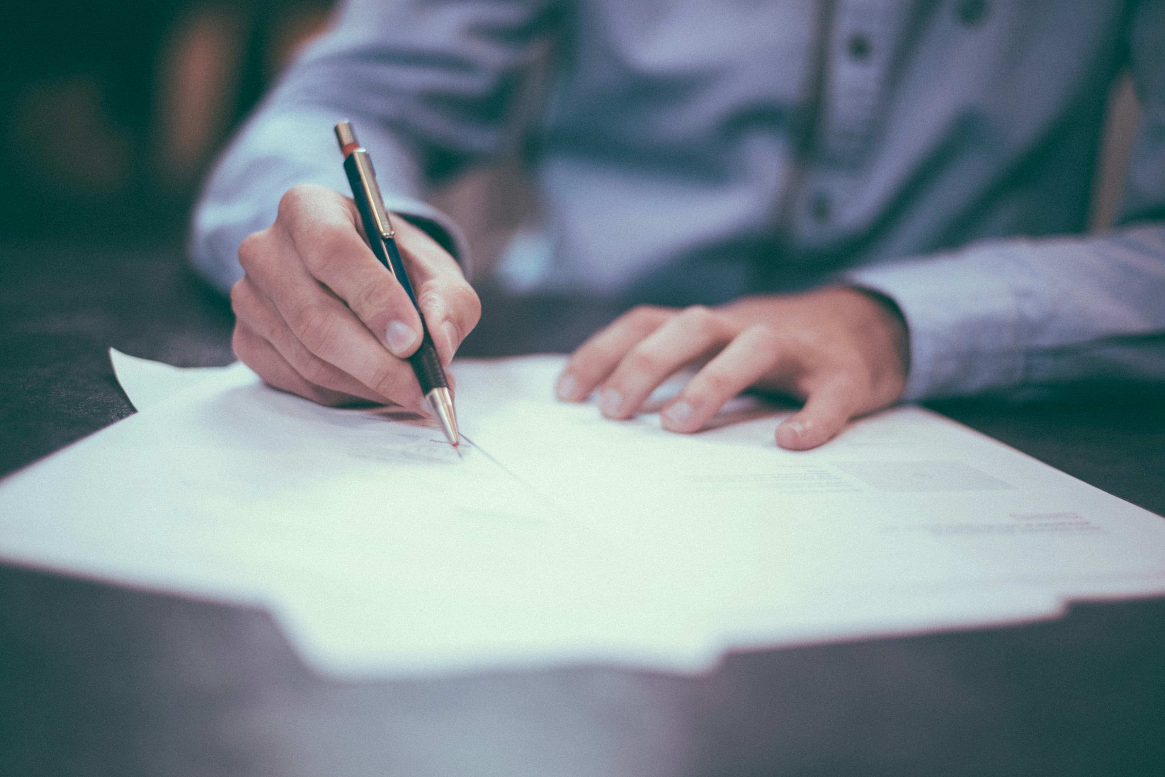 Hands signing divorce-related financial documents