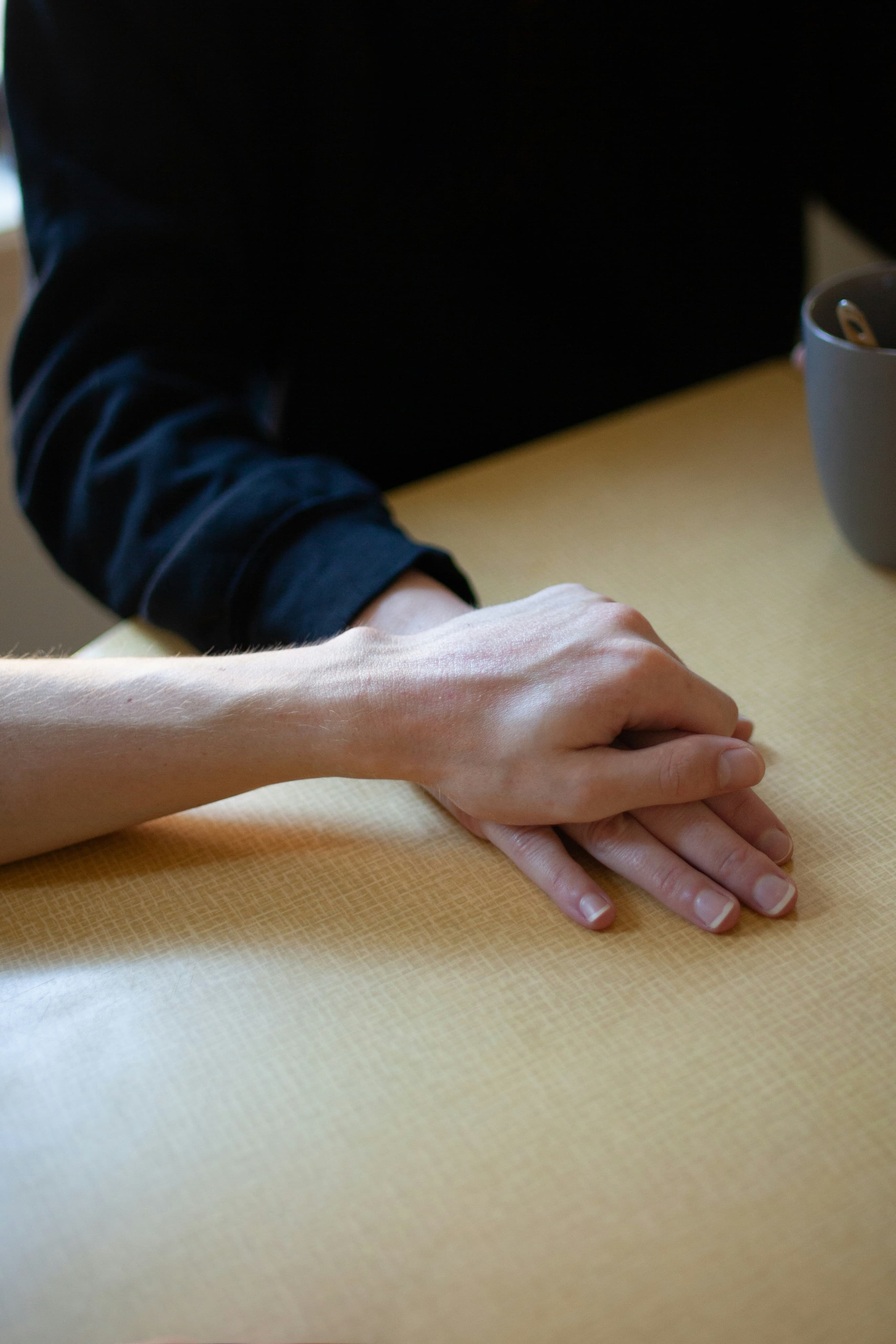 Hands resting on a table during a thoughtful legal consultation